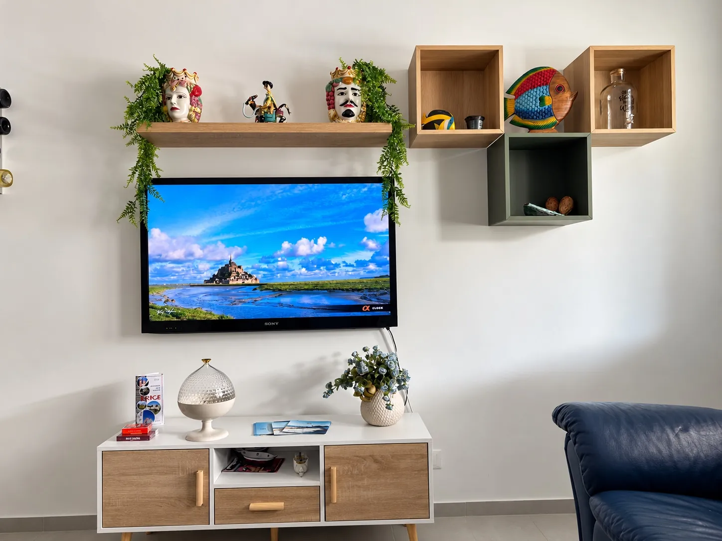 La parete della TV a schermo piatto, con le mensole e le teste di moro in ceramica