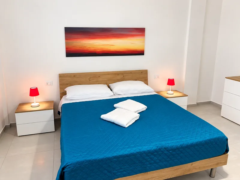 La prima camera dell'appartamento, con il letto matrimoniale e le lampade sui comodini