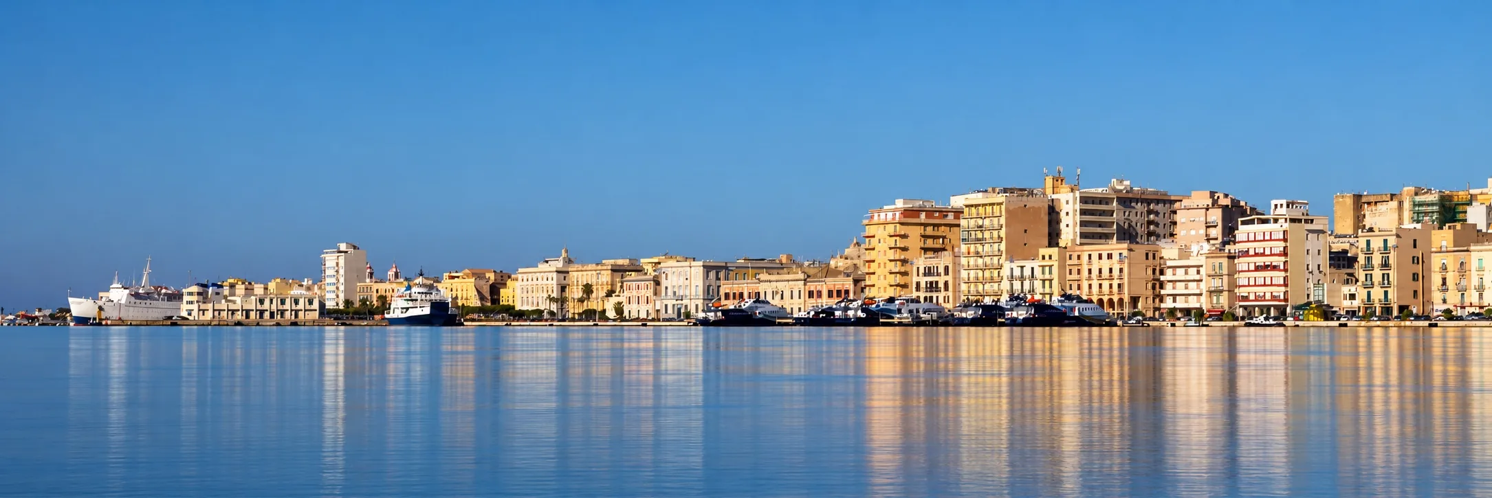 La città di Trapani affacciata sul mare, con i palazzi del lungomare e le barche ormeggiate