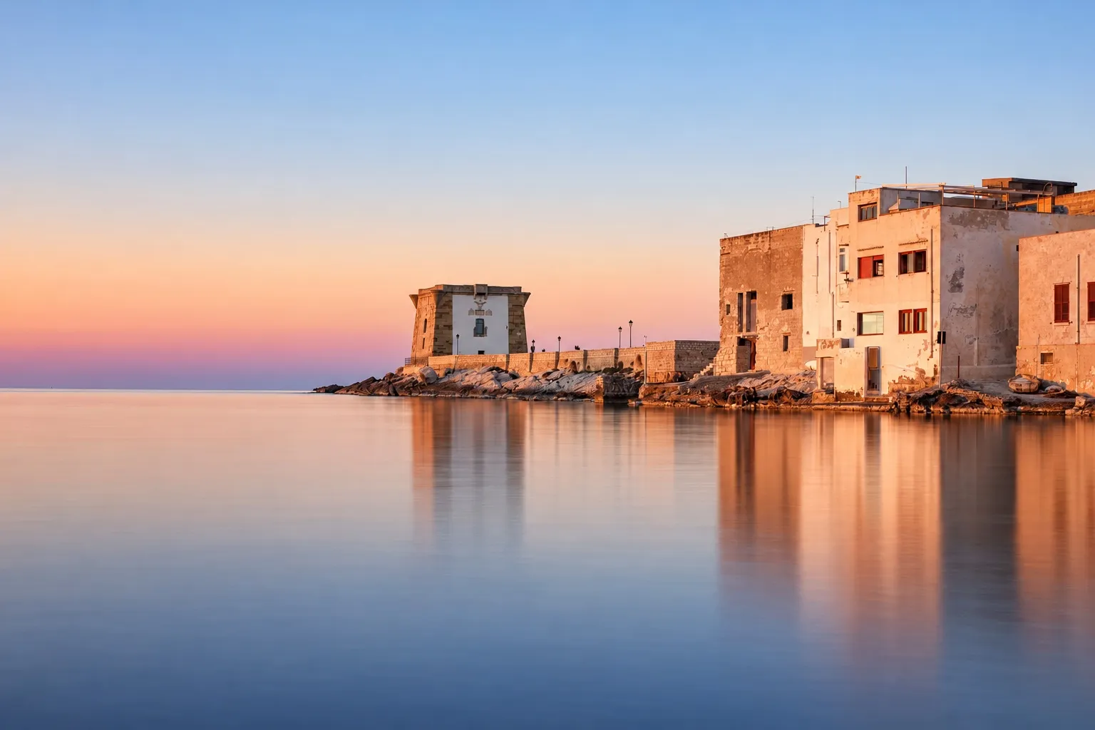 La Torre di Ligny a Trapani al tramonto, sul mare calmo